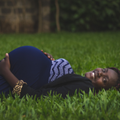 black pregnant woman lying in grass