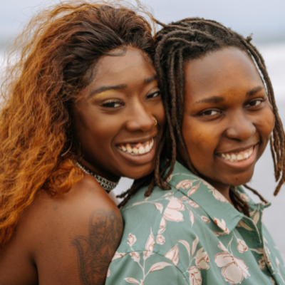 two queer women smiling 