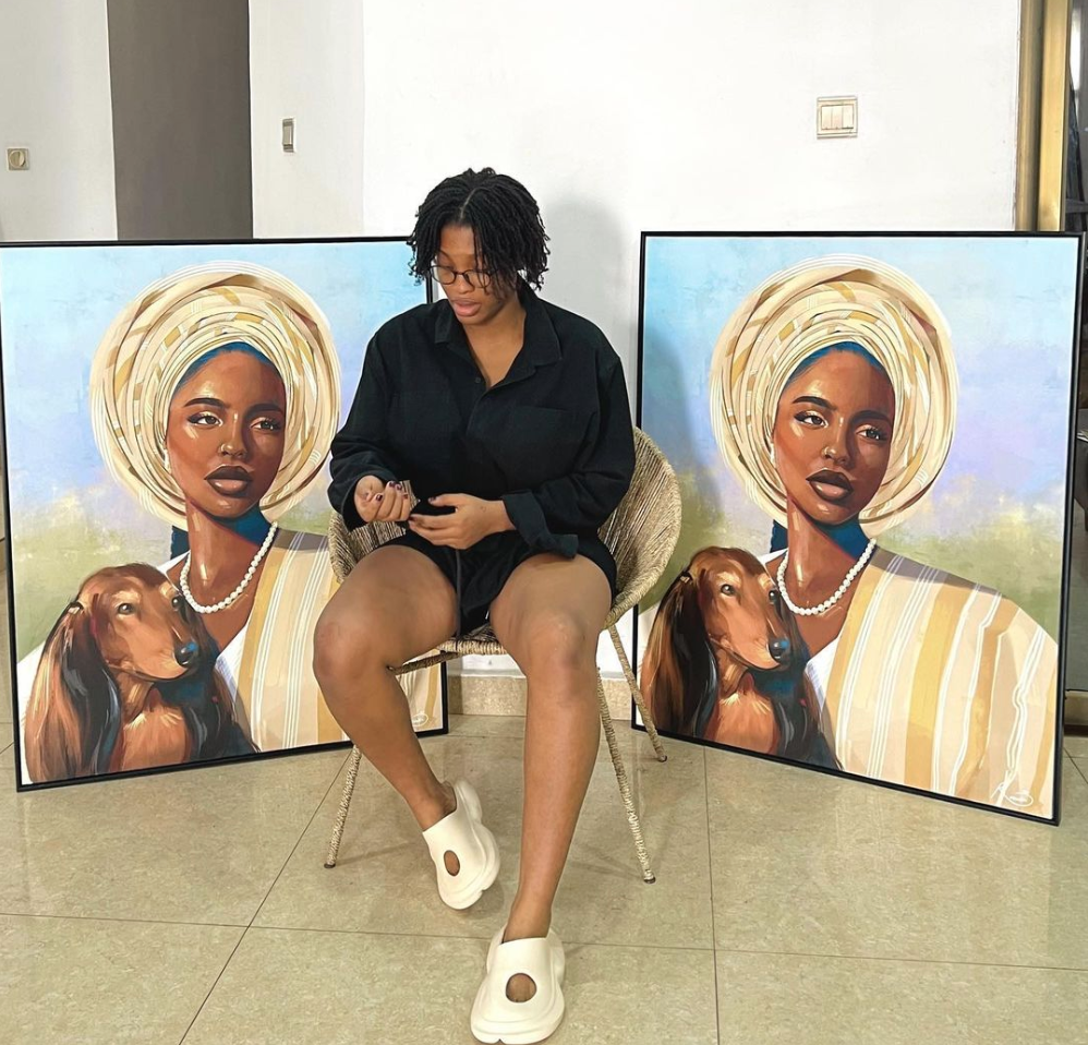 Renike the fine artist posing with her artworks